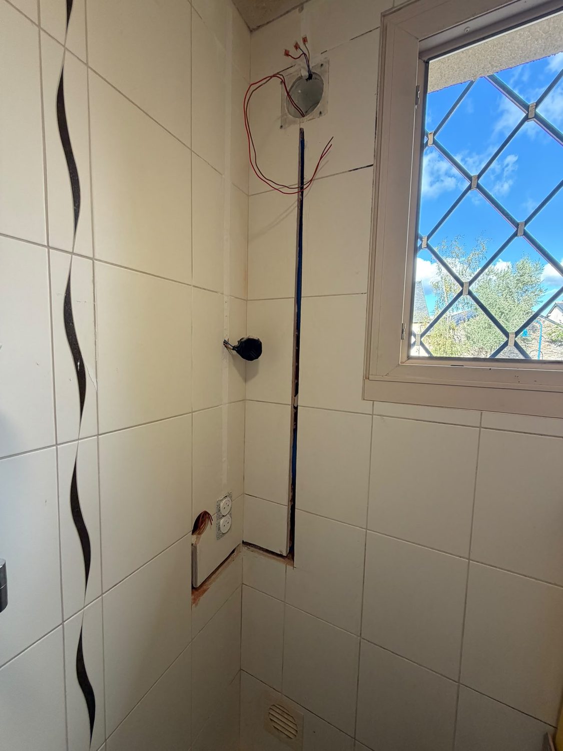 Saignée dans la faïence avec gaine électrique encastrée, avant la pose de l'appareillage, chantier LB Électricité